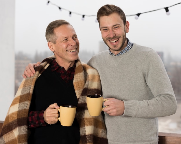 Bringen Sie mit der Decke hervor, die mit Sohn beim Halten von Schalen in den Händen aufwirft