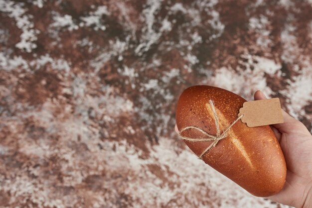 Brötchen auf dem Marmor in der Hand.