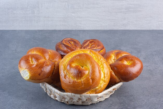 Brötchen auf einem kleinen Korb auf Marmor gestapelt.