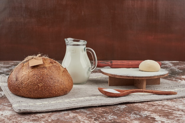 Brötchen auf grauem Küchentuch mit Zutaten.