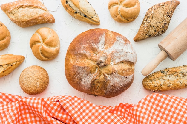 Kostenloses Foto brötchen und brot nahe nudelholz und gewebe