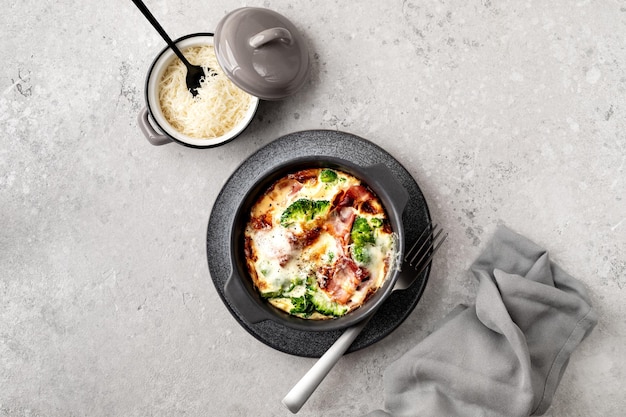 Brokkoli, Speck, Käse, Backen auf einem grauen Hintergrund