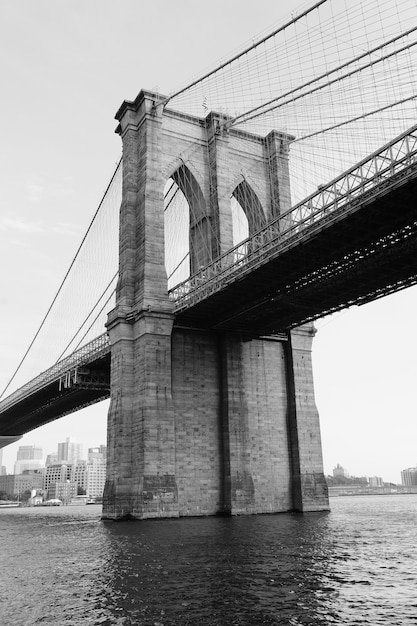 Brooklyn Bridge schwarz und weiß über den East River, gesehen von New York City Lower Manhattan Waterfront.