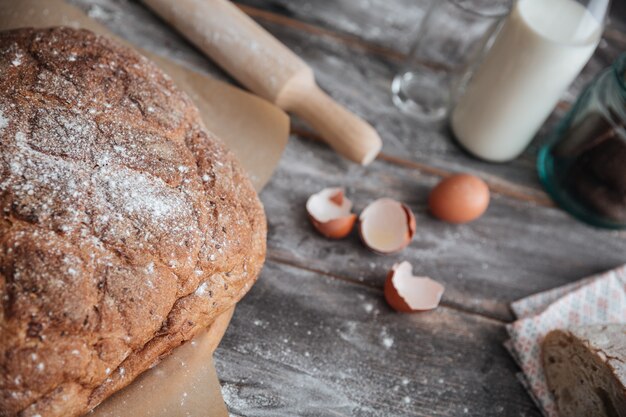 Brot in der Nähe von Eiern und Milch auf dem Tisch.