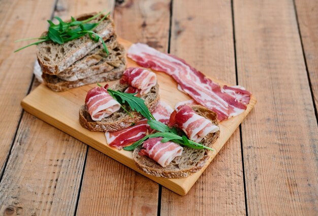 Brot mit Gourmet-Fleisch auf einem Holzschreibtisch über grünem Rasenhintergrund.