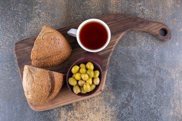 Brot mit grünen Oliven und einer Tasse Tee
