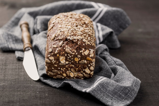 Brot mit Samen und Messer auf Stoff