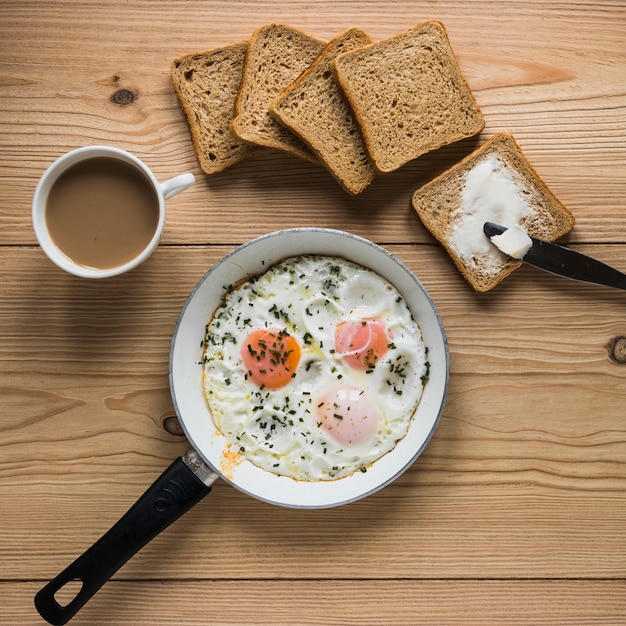 Brot und Kaffee in der Nähe von Spiegeleiern