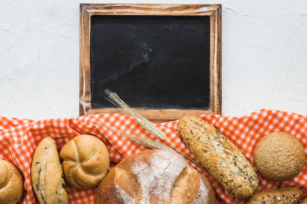 Kostenloses Foto brot und weizen auf gewebe nahe tafel