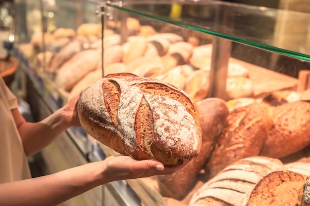 Kostenloses Foto brotlaib in weiblichen händen in einem supermarkt