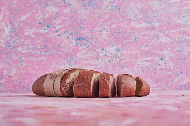 Brotscheiben auf einem rosa Tisch.