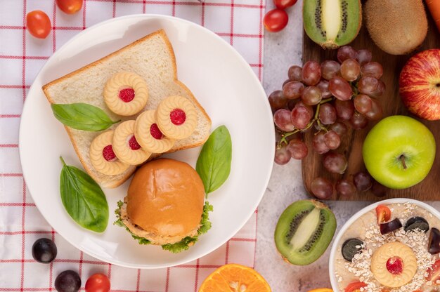 Brotscheiben, gefüllte Brötchen und Burger auf einem weißen Teller.