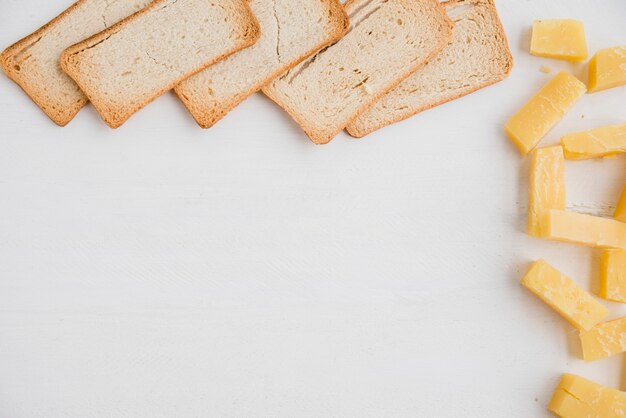 Brotscheiben mit Cheddar-Käsescheibe auf weißem Hintergrund