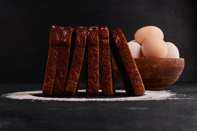 Brotscheiben mit Mehl und Eiern herum, Seitenansicht.