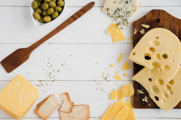 Brotscheiben mit Oliven; Brot und Käse auf weißem Schreibtisch