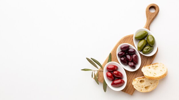 Brotscheiben und purpurrote rote grüne Oliven mit Kopienraum