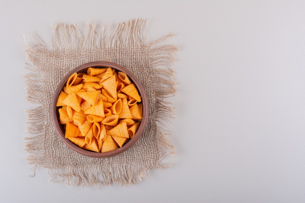 Brown-Schale mit Dreieckschips auf weißem Hintergrund. Foto in hoher Qualität