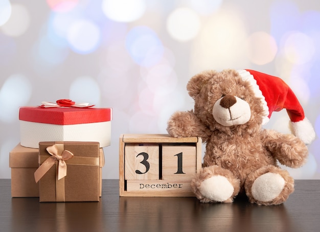 Brown-teddybär und ein stapel verschiedene pappschachteln für geschenke auf einer schwarzen tabelle