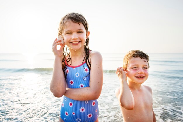 Bruder und Schwester, die den Strand genießen