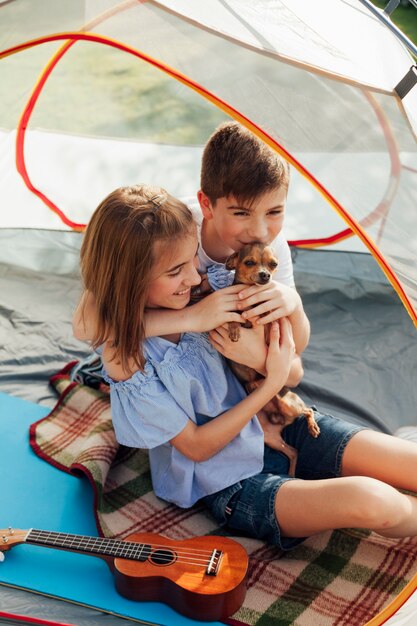 Bruder und Schwester, die ihr Haustier sitzt im Zelt lieben