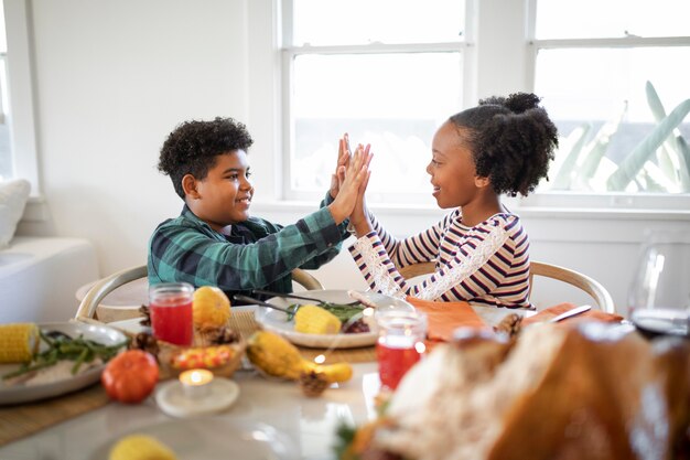 Bruder und Schwester High-Five nach dem Thanksgiving-Dinner