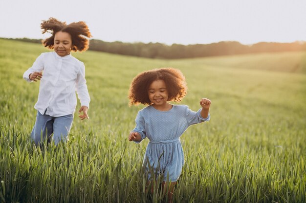 Bruder und Schwester zusammen auf dem Feld bei Sonnenuntergang