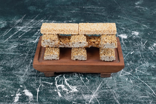 Kostenloses Foto brüchige bonbons mit samen und nüssen auf holzbrett.