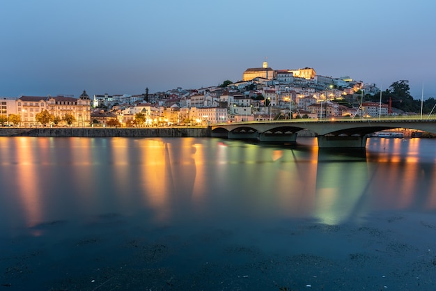 Brücke auf dem Meer, umgeben von Coimbra mit den Lichtern, die auf dem Wasser in Portugal reflektieren