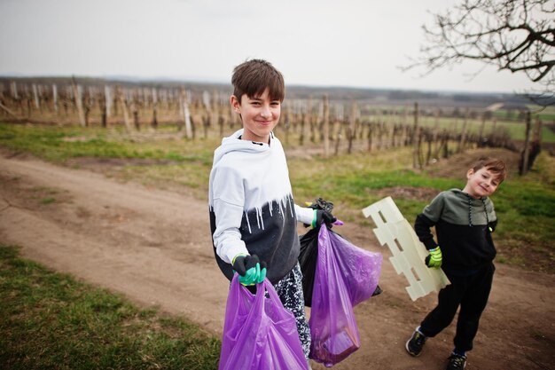 Brüder mit Müllsack sammeln Müll beim Reinigen in den Weinbergen Umweltschutz und Ökologie-Recycling