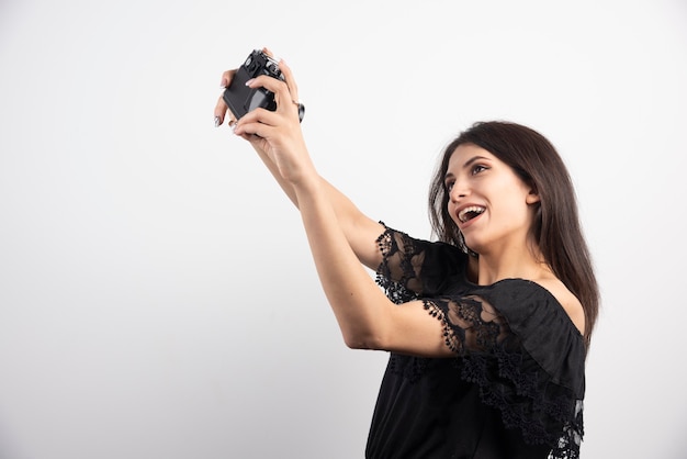 Brünette Frau, die Selfies mit Kamera nimmt