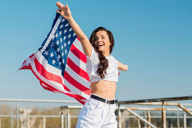 Brünette Frau hält große USA-Flagge