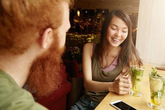 Brünette frau und ingwer mann sitzen im café