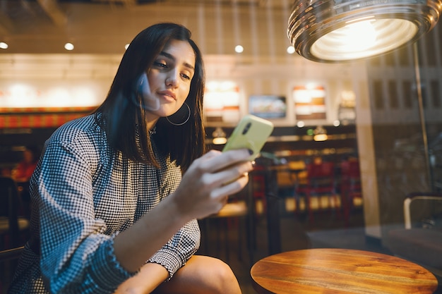 Brünette Mädchen mit ihrem Handy, um einen Freund zu erreichen