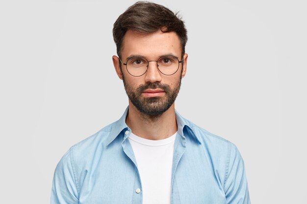 Brunet Mann trägt runde Brille und blaues Hemd