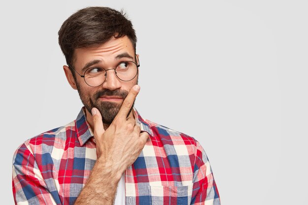 Brunet Mann trägt runde Brille und buntes Hemd