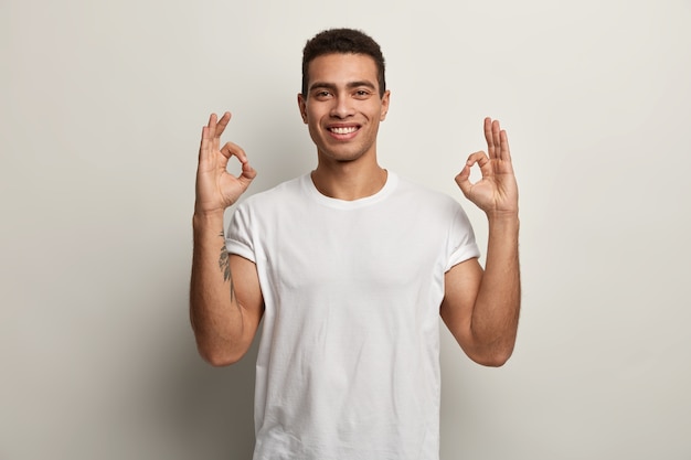 Brunet Mann trägt weißes T-Shirt