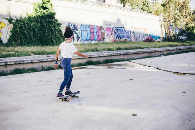 Brunette Mädchen Reiten Skateboard auf der Straße