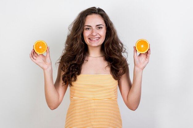 Brunettefrau, die eine Orange anhält