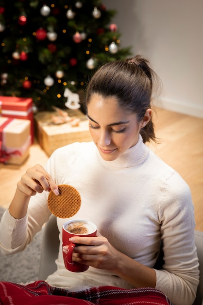 Brunettefrau, die einen Tasse Kaffee betrachtet