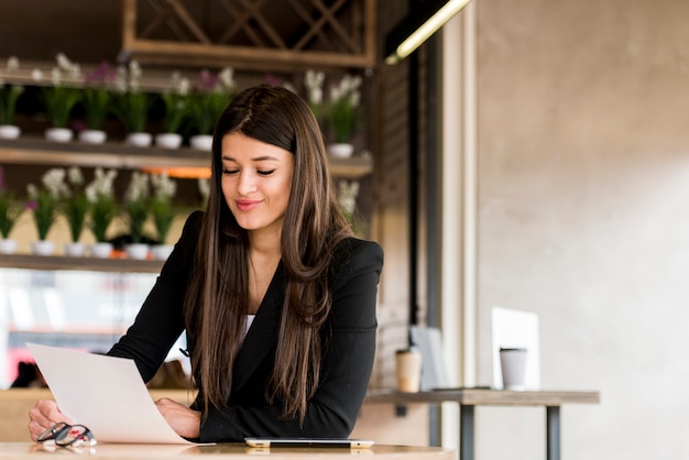 Brunettegeschäftsfrau, die Dokument liest