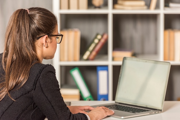 Kostenloses Foto brunettegeschäftsfrau, die in ihrem büro arbeitet