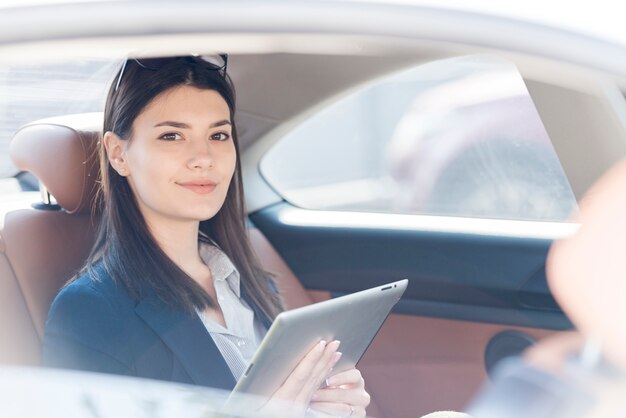 Brunettegeschäftsfrau, die innerhalb eines Autos aufwirft