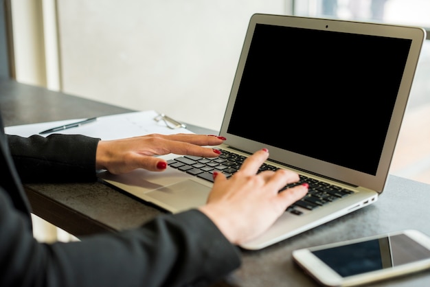 Brunettegeschäftsfrau, die Laptop verwendet