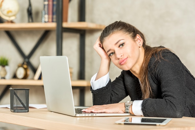 Brunettegeschäftsfrau gelangweilt in ihrem Büro