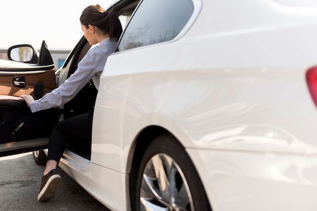 Brunettegeschäftsfrau mit Autodetail