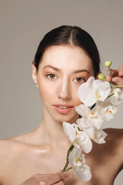 Brunettemädchen, das mit Blumen aufwirft