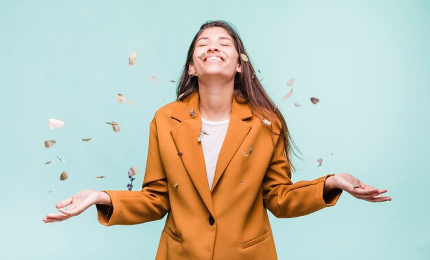 Brunettemädchen, das mit trockenen Blättern spielt