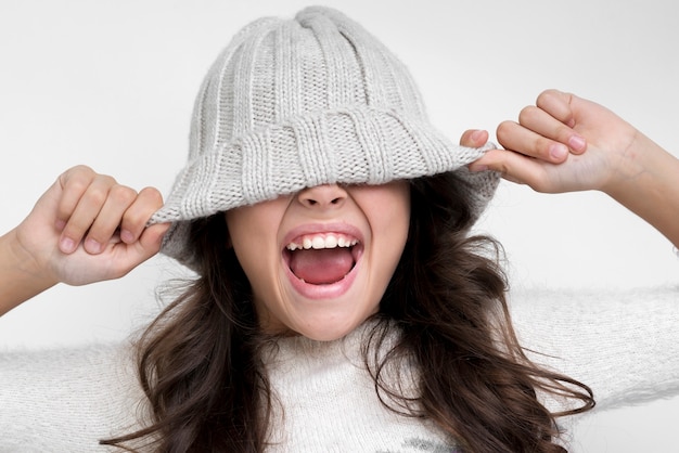 Kostenloses Foto brunettemädchen mit dem hut auf ihren augen schreiend