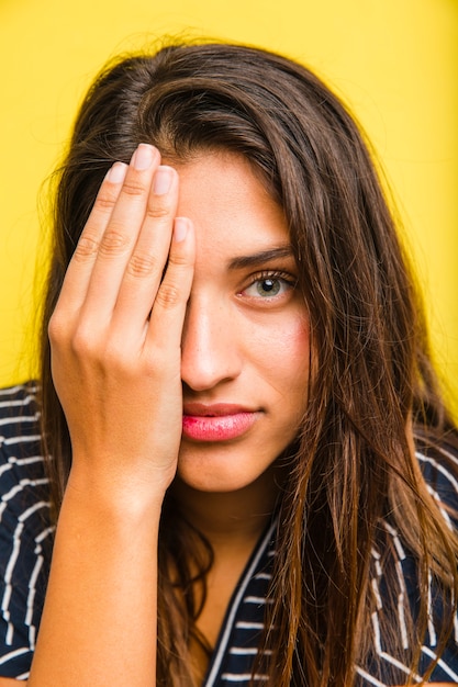 Kostenloses Foto brunettemädchen mit der hand auf dem gesicht