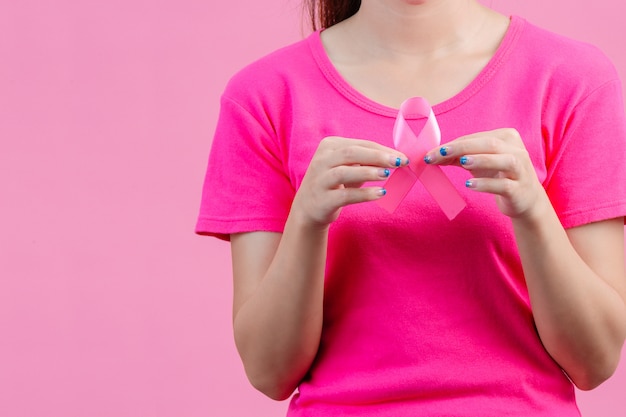 Brustkrebs-Bewusstsein montn, Frauen, die rosa Hemden tragen Ein rosa Band mit beiden Händen halten Zeigen Sie den symbolthe Tag gegen Brustkrebs